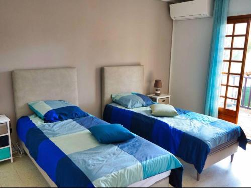 - 2 lits dans une chambre avec des oreillers bleus dans l'établissement Charmante villa provençale avec jardin et piscine privée à Saint-Cyr-sur-Mer - FR-1-770-44, à Saint-Cyr-sur-Mer