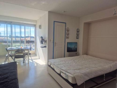 - une chambre avec un lit, une table et un balcon dans l'établissement Studio cabine 4 personnes avec parking - Cap d'Agde - FR-1-249-424, au Cap d'Agde