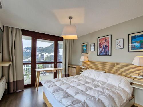une chambre avec un grand lit blanc et un balcon dans l'établissement Appartement spacieux - Départ skis aux pieds - Piscine & Parking inclus - FR-1-425-231, à Arâches-la-Frasse