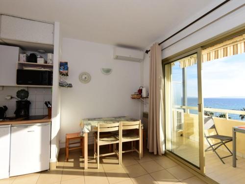 une cuisine avec une table et une vue sur l'océan dans l'établissement Le Lavandou: Studio 4 pers. vue mer, parking, clim - FR-1-803-92, au Lavandou