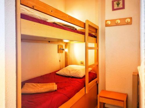 - une chambre avec 2 lits superposés et des draps rouges dans l'établissement Le Lavandou: Studio 4 pers. vue mer, parking, clim - FR-1-803-92, au Lavandou