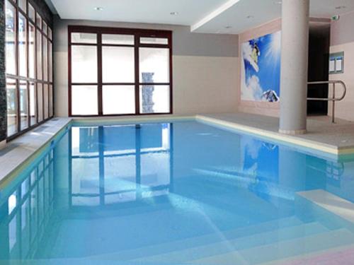 - une grande piscine d'eau bleue dans une chambre dans l'établissement Appartement spacieux - Départ skis aux pieds - Piscine & Parking inclus - FR-1-425-231, à Arâches-la-Frasse
