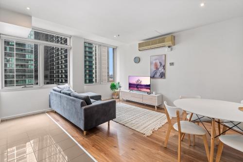 a living room with a couch and a table at Melbourne CBD 2BR Apt with Pool & Gym Access in Melbourne