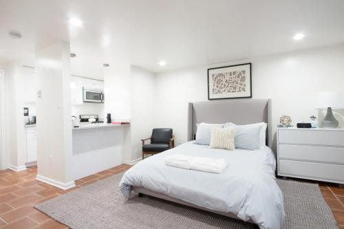 a white bedroom with a bed and a kitchen at WELL-EQUIPPED STUDIO APT - WALK TO METRO SUBWAY in Washington, D.C.