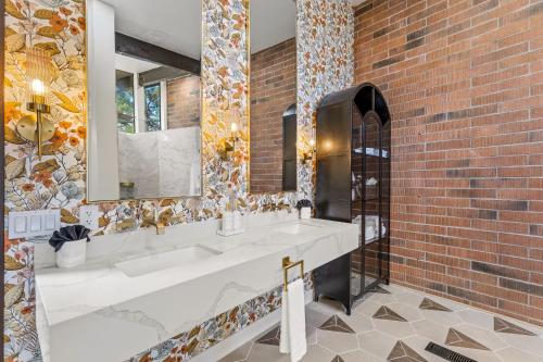 セドナにあるThe Speakeasy - Sauna, Cold Plunge and Hot Tubのレンガの壁、洗面台2台付きのバスルーム