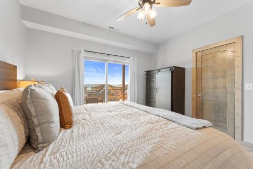 a bedroom with a bed with a ceiling fan and a window at Summertime Shores - 127 in Branson
