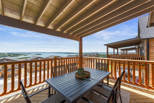a wooden deck with a table and chairs on it at Summertime Shores - 127 in Branson