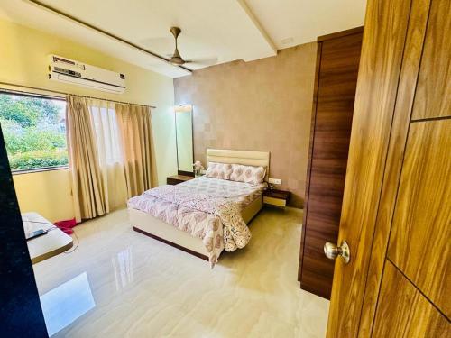 a bedroom with a bed and a window at Katha Villa 63 - Luxury Holiday Home in Karjat