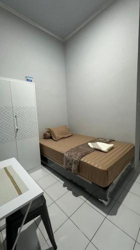 a bedroom with a bed in a white room at Sultan Agung Homestay Syariah in Magelang