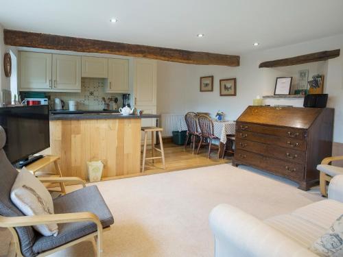 a living room with a kitchen and a dining room at Castle House Cottage in Kirkby Stephen