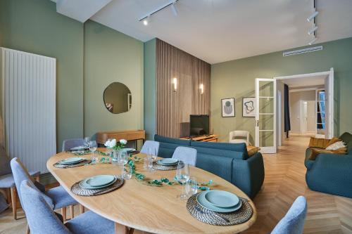 une salle à manger avec une table et un canapé bleu dans l'établissement Elegant 2-bedroom apartment - Trocadéro, à Paris