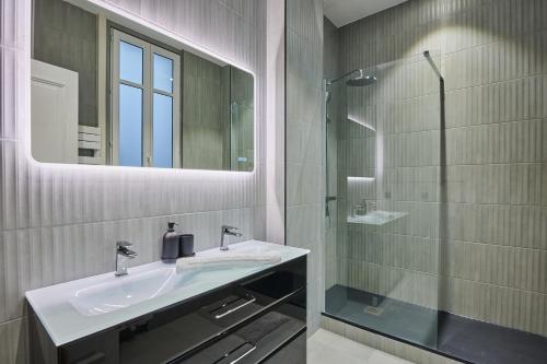 une salle de bain avec un lavabo et une douche en verre dans l'établissement Elegant 2-bedroom apartment - Trocadéro, à Paris