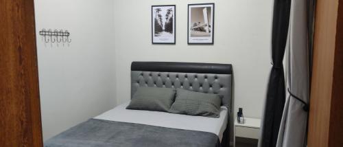 a small bedroom with a bed and two pictures on the wall at Loft Cruzeiro in Belo Horizonte