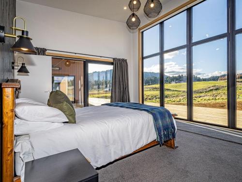 a bedroom with a bed and a large window at Taylors Alpine Retreat in Ohakune