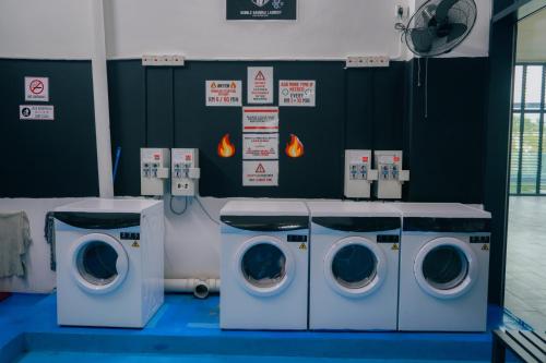 a laundry room with two washing machines and signs at The Place Cyberjaya Duplex with Putrajaya View in Cyberjaya
