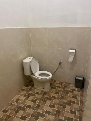 a bathroom with a toilet in a tiled floor at Tangkoko Macaca in Rinondoran