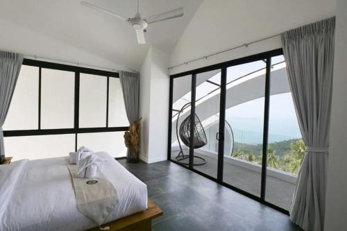 チャウエンノイビーチにあるVilla Moon Paradise 4br Infinity Pool Viewsの大きなベッドと大きな窓のある寝室