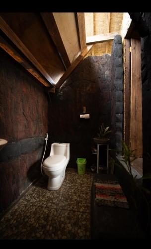 a bathroom with a toilet in a brick wall at Citra Homestay in Tetebatu