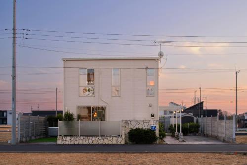 a white house with a fence in front of it at Pool Villa Mito - Pool Villa 水戸 in Mito