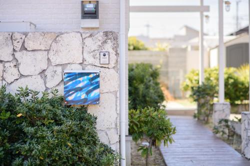 a stone wall with a painting on the side of a house at Pool Villa Mito - Pool Villa 水戸 in Mito