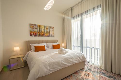 a white bedroom with a bed and a large window at Family Getaway Villa in Ras al Khaimah