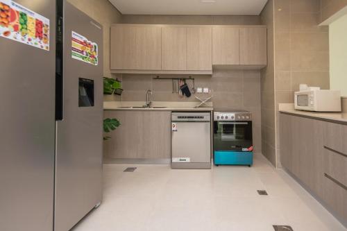 a small kitchen with a refrigerator and a sink at Family Getaway Villa in Ras al Khaimah