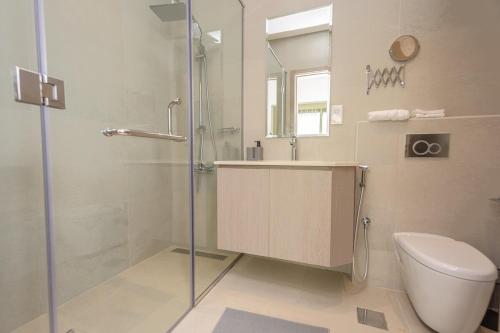 a bathroom with a shower and a toilet and a sink at Family Getaway Villa in Ras al Khaimah