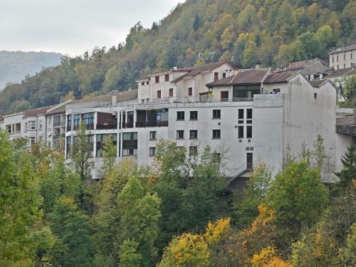 a large white building on a hill with trees at Jura Hotel Restaurant Le Panoramic in Saint-Claude
