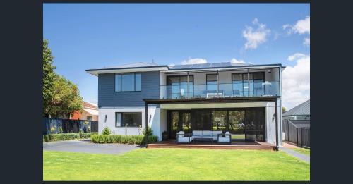 a large house with a porch and a lawn at Huge Luxury Busselton Jetty in Busselton