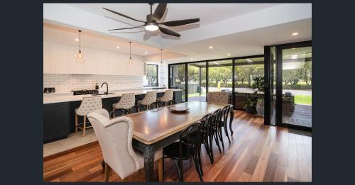 a kitchen and dining room with a wooden table and chairs at Huge Luxury Busselton Jetty in Busselton