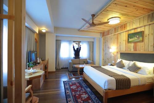 a hotel room with a bed and a person jumping out the window at Hotel Phuntsho pelri in Thimphu