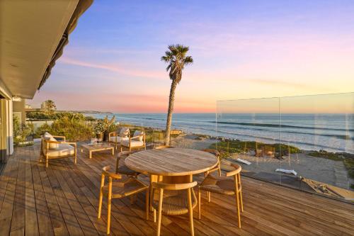 a wooden deck with a table and chairs and a palm tree at The Surf Lodge Villa in Malibu