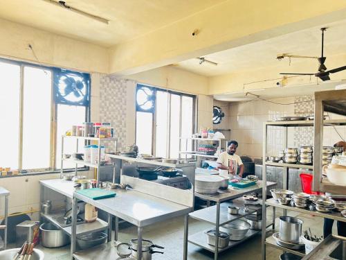 a man in a kitchen preparing food in a kitchen at Hotel Mayur Residency in Kalyan
