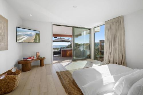 a bedroom with a white bed and a large window at The Surf Lodge Villa in Malibu