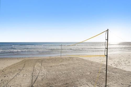 a volleyball net on a beach with the ocean at The Surf Lodge Villa in Malibu