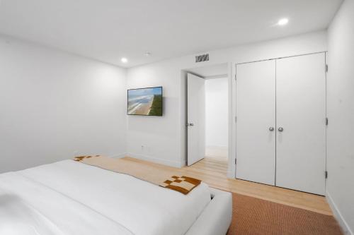 a white bedroom with a white bed and a couch at The Surf Lodge Villa in Malibu
