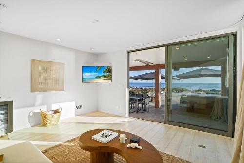 a living room with a table and a view of the ocean at The Surf Lodge Villa in Malibu