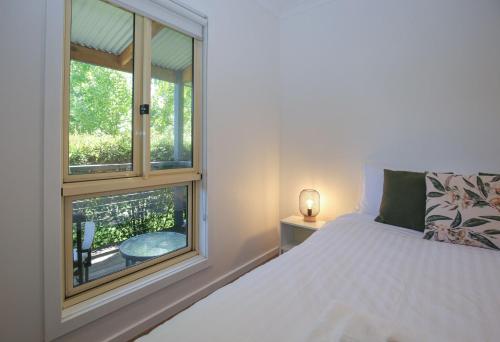 a bedroom with a bed and a window at Houghs Cabin in Bright