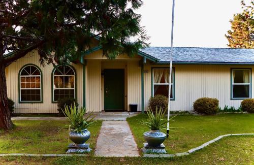 a house with two potted plants in front of it at Sequoia vacation home in Baker and Hall Airport