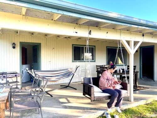 a woman sitting on a chair on a porch at Sequoia vacation home in Baker and Hall Airport