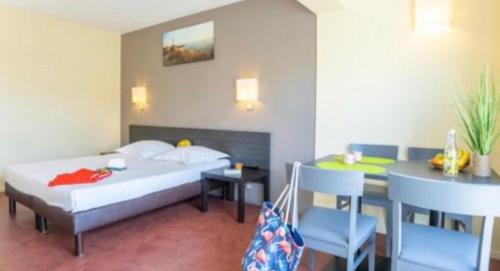 une chambre d'hôtel avec un lit, une table et des chaises dans l'établissement Les hameaux de Camargue 726, à Arles