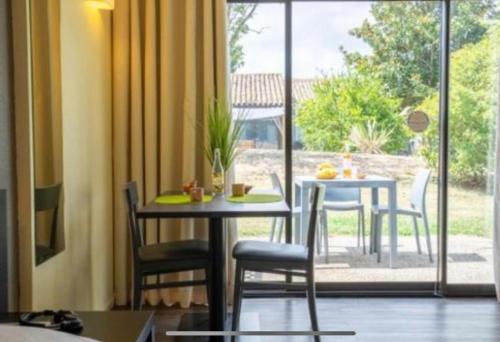 une salle à manger avec une table et des chaises et une fenêtre dans l'établissement Les hameaux de Camargue 726, à Arles