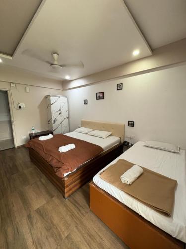 a bedroom with two beds and a mirror at White House Beach Resort, Nagaon in Nagaon