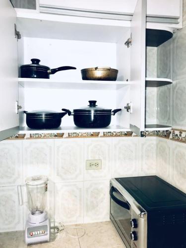 a kitchen with pots and pans on a shelf at Guatapurí Apartments & Relax in Valledupar