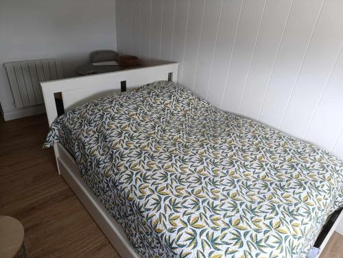 a bed in a white room with a bedskirtspectspectssenalsenalsenalsenal at Charmant petit Studio a Dax in Dax