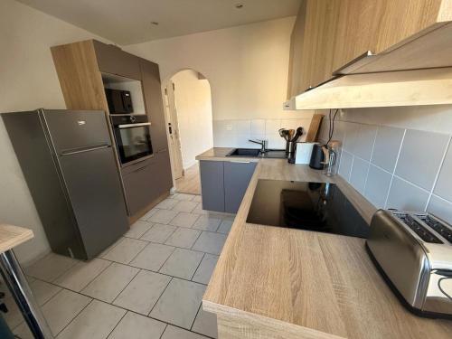 une cuisine avec un réfrigérateur et un plan de travail dans l'établissement Le coin des fourmis, à Louvres