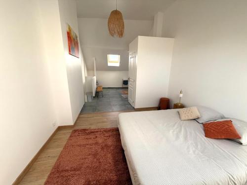 - une chambre avec un lit blanc et un couloir dans l'établissement Le coin des fourmis, à Louvres