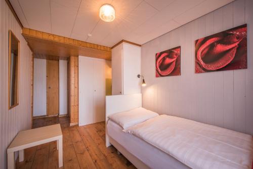 a small bedroom with a bed and a table at Hotel Tell and Apartments in Interlaken