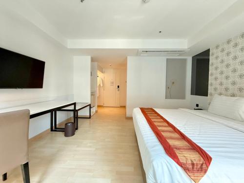 a hotel room with a bed and a desk at Le D'Tel Bangkok in Bangkok