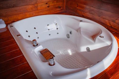 a white bath tub in a room with wooden walls at Aldea Tipi Glamping in Tapalpa